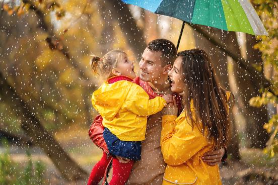 parents with small child under an umbrella in the rain