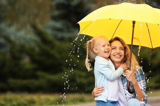 Woman and girl under an umbrella, laughing