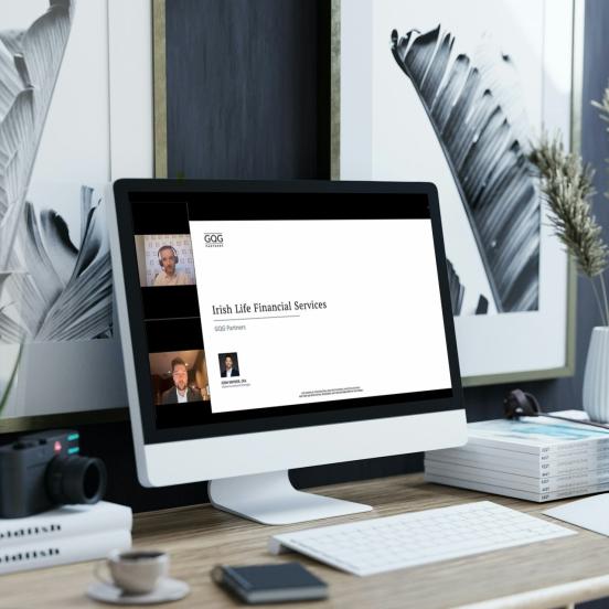 An imac in a modern room with a webinar from GQG and Irish Life on the screen
