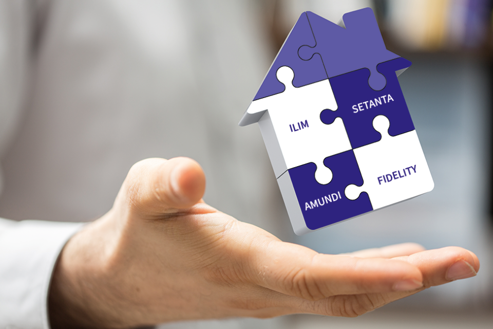 Photo of a person holding a house shaped object featuring investment managers' names