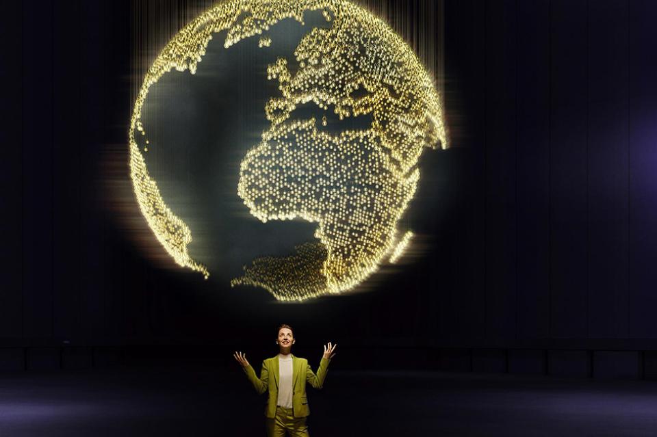 image of woman standing beneath an illuminated globe