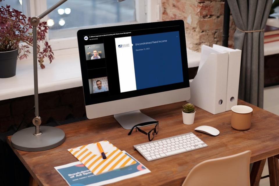 A desk with a monitory showing playback of the Reams webinar with Richard Gallagher